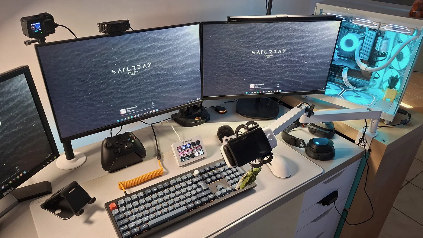 Le bureau vu en légère plongée : clavier, Stream Deck, manette Xbox, casque, souris et bras articulé blanc.